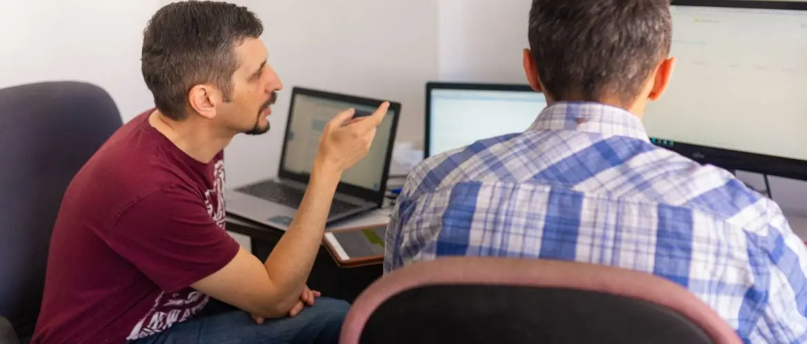 agile software development developers discussing in front of laptops
